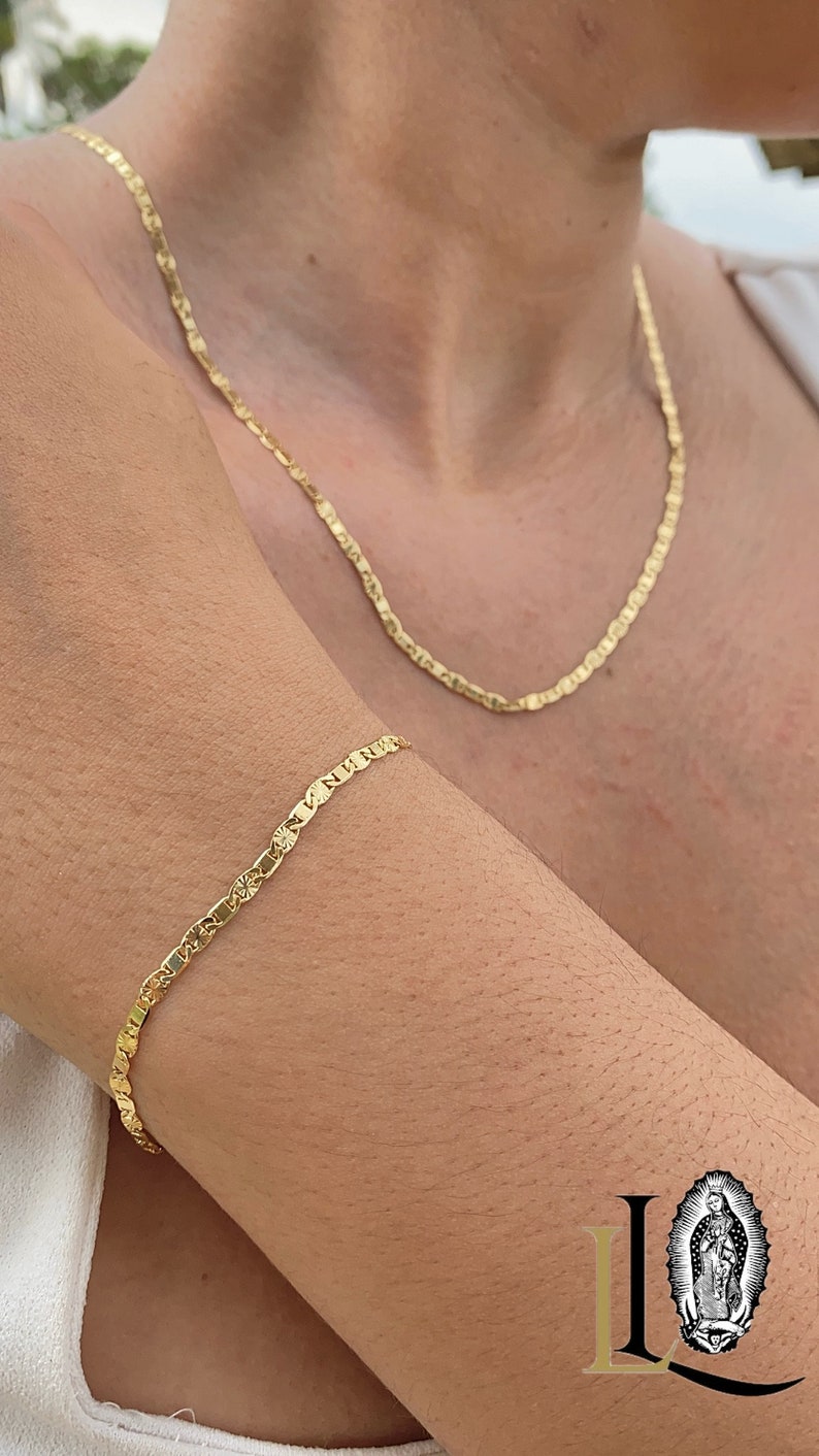 May include: A gold chain necklace and bracelet with a delicate, textured design. The necklace is worn around the neck and the bracelet is worn on the wrist.