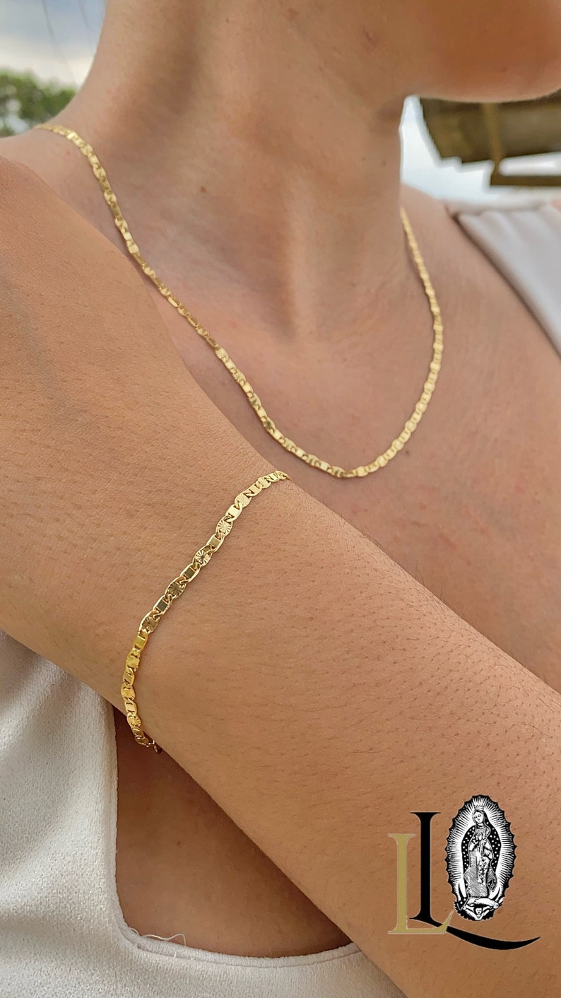May include: A gold chain necklace and bracelet with a delicate, patterned design. The necklace is worn around the neck and the bracelet is worn on the wrist.