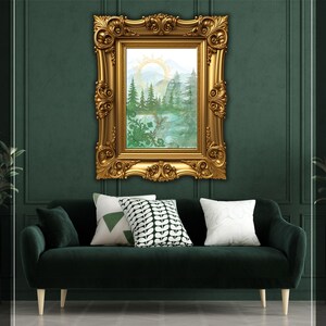 Puede incluir: Una pintura de paisaje enmarcada en oro adornado cuelga sobre un sofá de terciopelo verde oscuro con cojines decorativos. La pintura representa una escena de bosque con un sol y montañas. Los cojines tienen patrones blancos y verdes.
