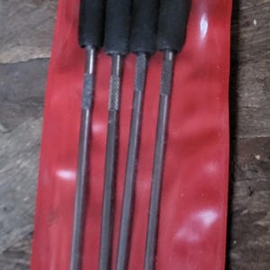 May include: A set of four Blue-Point brand pick tools in a red plastic package. The tools have black handles and metal shafts. The brand name is printed in white on the handles.