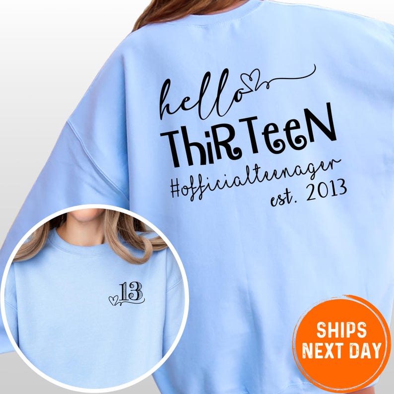 A person wearing a light blue sweatshirt with text printed on the back.
