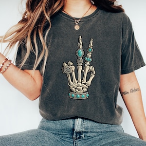 a woman wearing a t - shirt with a skeleton hand on it