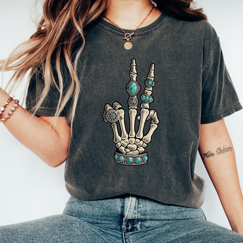 a woman wearing a t - shirt with a skeleton hand on it