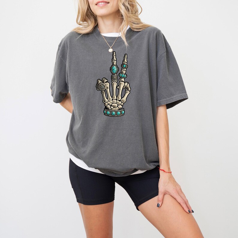 a woman wearing shorts and a t - shirt with a hand drawn on it