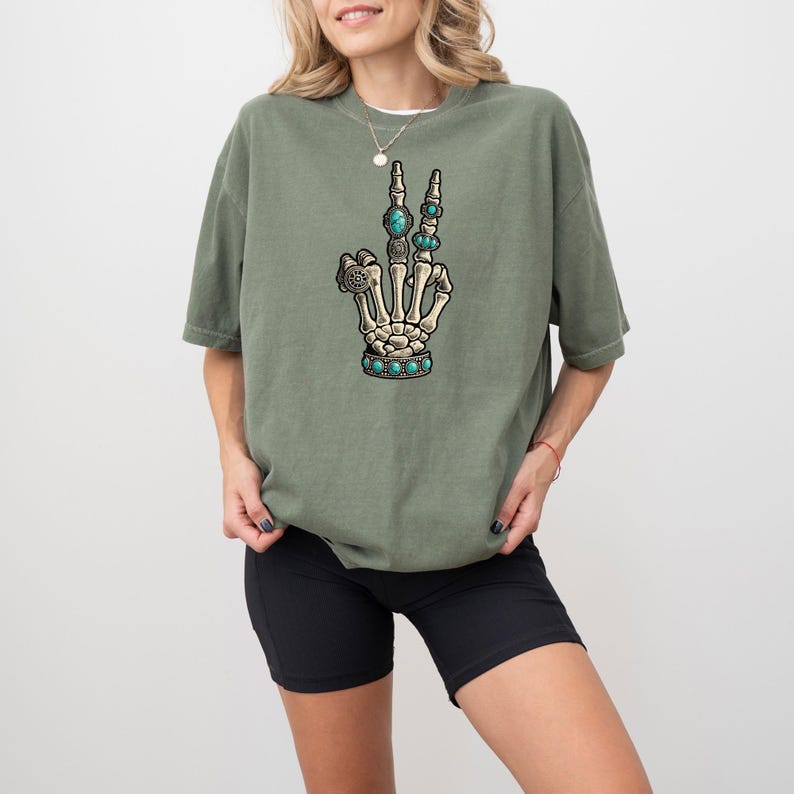 a woman wearing a green shirt with a skeleton hand on it