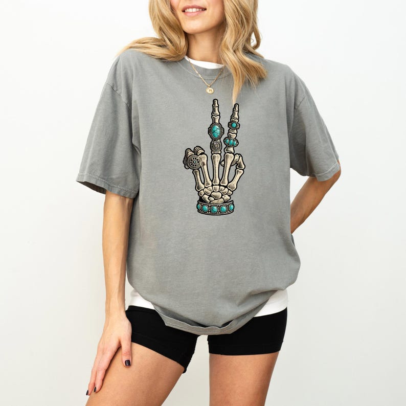 a woman wearing a gray shirt with a hand drawn on it