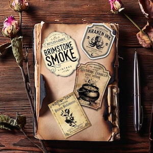 May include: A vintage-style book with four decorative labels featuring text like "Brimstone Smoke" and "Kraken Ink." The labels have a distressed, aged appearance. A silver pen and dried flowers are also present, creating a rustic, apothecary theme.