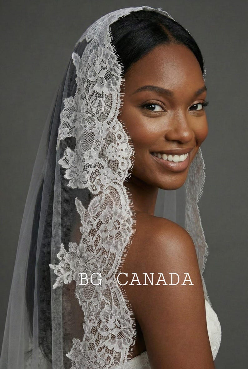 May include: A white lace bridal veil with floral and leaf patterns. The veil is draped over the head and shoulders. The text "BG CANADA" is visible on the veil.