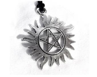 May include: A silver pendant necklace featuring a five-pointed star inside a circle with a sunburst design.