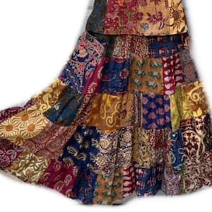 May include: A multi-colored patchwork skirt with a variety of floral and geometric patterns. The skirt is made of different fabrics and has a tiered design.