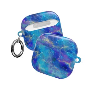 Könnte beinhalten: Zwei AirPod-Hüllen mit blauem und violettem Marmormuster. Eine Hülle ist geöffnet und zeigt einen weißen AirPod. Ein silberner Karabinerhaken ist an der offenen Hülle befestigt. Die Hüllen haben ein glänzendes Finish und ein schützendes Design.