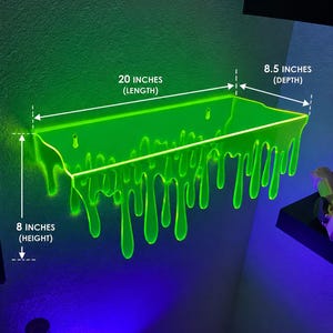May include: A neon green wall-mounted shelf with a dripping liquid design. The shelf features keyhole mounting slots and measures 20 inches in length, 8.5 inches in depth, and 8 inches in height as indicated by the text labels on the image.