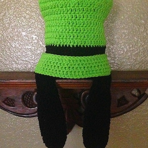 May include: Green and black crocheted hat with long black crocheted ear flaps.