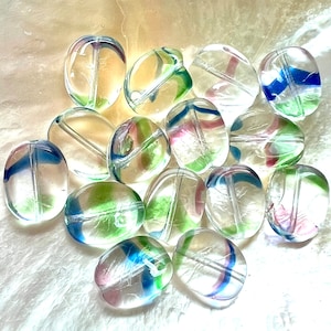 May include: A collection of clear, oval-shaped glass beads with colorful, swirled accents of blue, green, and pink. The beads are strung with a hole running through the center, perfect for jewelry making or crafting projects.