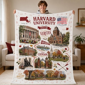 Könnte beinhalten: Eine weiße Decke mit einer detaillierten Illustration von Wahrzeichen der Harvard University, darunter die Widener Library und die Memorial Hall. Auf der Decke sind die Worte "Harvard University" und "Veritas" sowie die amerikanische Flagge aufgedruckt.
