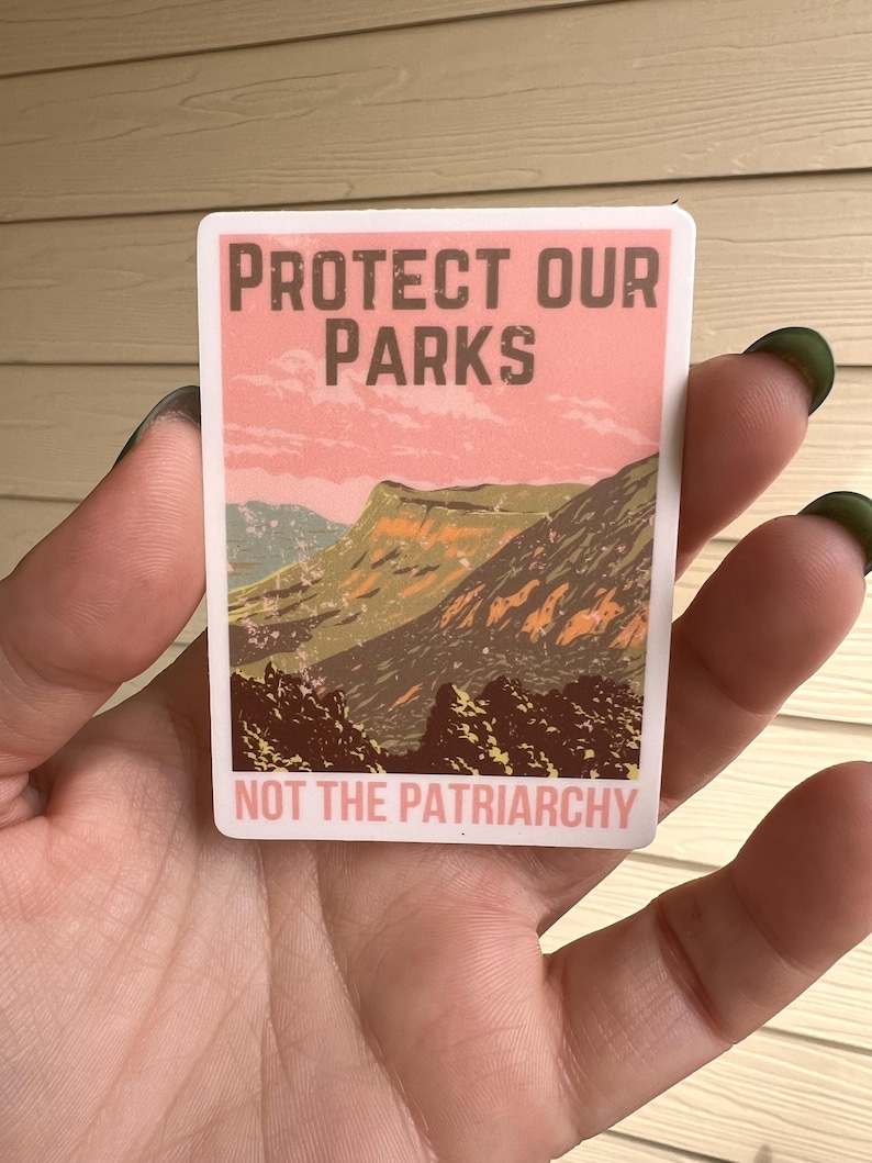 May include: A sticker with a pink and green mountain landscape and the text "Protect Our Parks Not The Patriarchy".