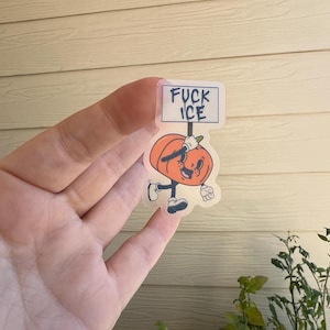 May include: A clear sticker featuring a cartoon pumpkin character holding a sign that reads "FUCK ICE". The pumpkin is orange with a smiling face, black shoes, and white gloves. The sign is white with black text.