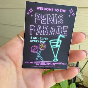 Puede incluir: Una pegatina rectangular con fondo negro y texto estilo neón que dice WELCOME TO THE PENIS PARADE, 5 AM - 11 PM EVERY DAY, VISIT THE CUM CLOSET TODAY - FIRST FLOOR OF THE DESPERADO CLUB, CLOTHING OPTIONAL, DIGNITY NOT ACCEPTED.