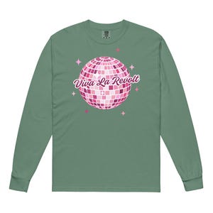 May include: A green long-sleeved t-shirt with a pink disco ball graphic and the text "Viva La Revolt" printed on the front.