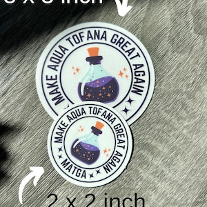 May include: Two round stickers with a white background and black text. The larger sticker is 3 inches in diameter and the smaller sticker is 2 inches in diameter. Both stickers feature a purple potion bottle with stars and the text "Make Aqua Tofana Great Again".