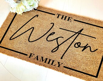 May include: A brown coir doormat with a black border and the text "THE Weston FAMILY" in black lettering.