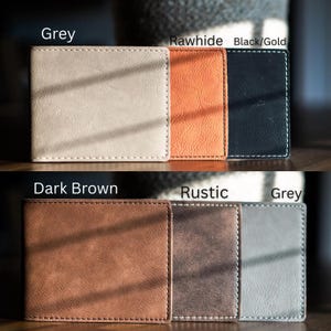 May include: Six rectangular bi-fold wallets arranged in two rows. The top row features grey, rawhide, and black/gold wallets. The bottom row displays dark brown, rustic, and grey wallets. Each wallet has visible white stitching along the edges.