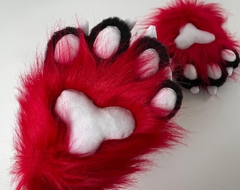 May include: A pair of red furry paw hand puppets with black accents and white paw pads.