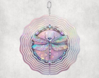 May include: A metal wind spinner with a circular design featuring a dragonfly with iridescent wings. The dragonfly is surrounded by a decorative frame with jewels and a pink and purple background.