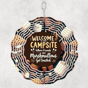 May include: A white metal wind chime with a circular design. The chime features a black and white pattern with images of marshmallows, campfires, and the text "Welcome to our Campsite Where Friends and Marshmallows Get Toasted".
