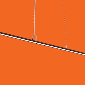 Pode incluir: Uma luminária pendente longa, fina e preta pendurada no teto. A luminária é suspensa por dois fios finos. A luminária está sobre um fundo laranja brilhante.