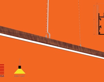 May include: A long, rectangular, wooden pendant light fixture with a white light source. The fixture is suspended from the ceiling by two wires. The fixture is made of wood with a natural wood grain finish. The light source is a linear LED strip. The fixture is 48 inches long and 3 inches wide. The fixture is made in the USA. Direct light.