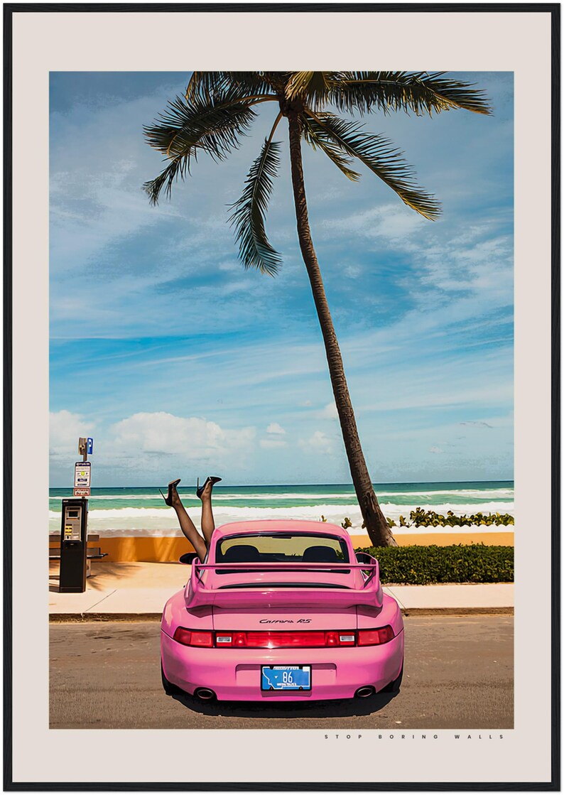 Puede incluir: Un Porsche Carrera 4S rosa estacionado en una carretera de playa con una palmera de fondo. Un par de piernas sobresalen por la ventana trasera del coche. El texto "STOP BORING WALLS" est&aacute; impreso debajo del coche.