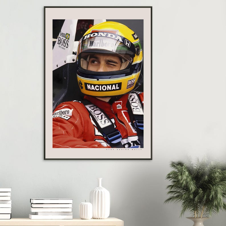 May include: A close-up of a race car driver wearing a yellow and black helmet with the word "HONDA" and "MARLBORO" on it. The driver is wearing a red racing suit with the word "BOSS" on it. The driver is looking to the right of the image.