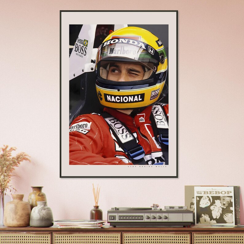 May include: A close-up of a race car driver wearing a yellow and black helmet with the word "HONDA" and "Marlboro" on it. The driver is wearing a red racing suit with the word "NACIONAL" on the helmet and "BOSS" on the suit.