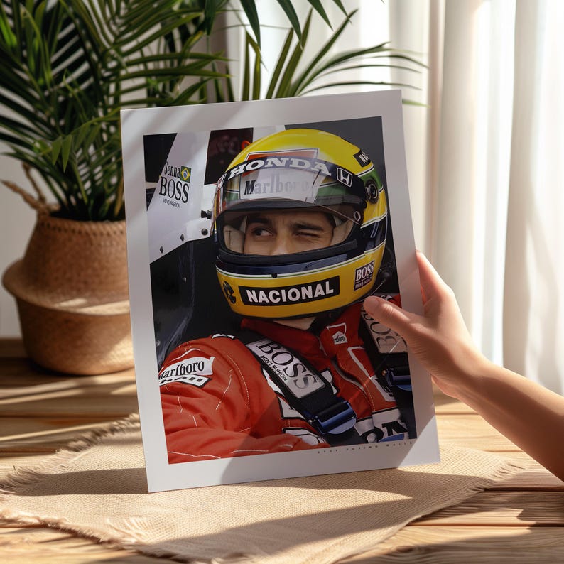 May include: A close-up of a race car driver wearing a yellow and black helmet with the word "Marlboro" on it. The driver is wearing a red racing suit with the words "Nacional" and "Boss" on it. The driver is winking at the camera.