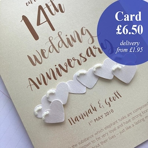 May include: A cream-colored anniversary card with the text "on our 14th Wedding Anniversary" in a brown script. The card features white heart embellishments and the names "Hannah & Geoff" with the date "1st May 2010".