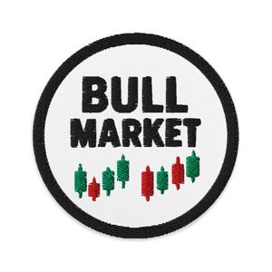 Puede incluir: Parche bordado circular con la inscripción "BULL MARKET" en negro sobre fondo blanco. El diseño incluye un borde negro y un gráfico de gráficos de velas verdes y rojas.
