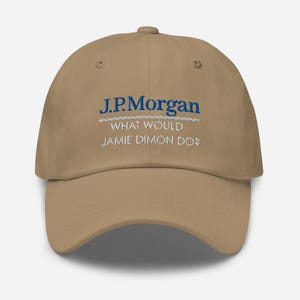 May include: A tan baseball cap with the text "J.P. Morgan" in blue, above the phrase "WHAT WOULD JAMIE DIMON DO?" in white. The hat has a curved brim and a button on top.