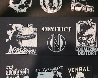 Puede incluir: Una colección de nueve parches de tela negra con gráficos y texto serigrafiados en blanco. Los diseños incluyen nombres de bandas y logotipos como Toxic Narcotic, Oi Polloi, Funeral Dress, Agression, Conflict, Gauze, Forward to Battle, SS-Kaliert y Verbal Abuse.