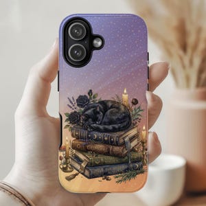 May include: A smartphone case with a purple and orange gradient background featuring a black cat sleeping on a stack of four books. The books are labeled Grimoire, Natural Magick, and The Witch's Almanac, surrounded by candles, roses, and greenery.