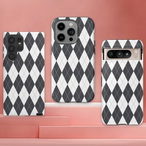 May include: Three phone cases with a black and white diamond pattern. The cases are for different phone models.
