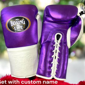 May include: A pair of purple boxing gloves with white laces and a white cuff. The gloves have the text "NO BOXING NO LIFE" on the front.