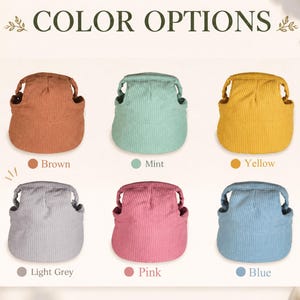 May include: A collection of six corduroy protective head cushions arranged in two rows. The colors include brown, mint, yellow, light grey, pink, and blue. Each item features a rounded top with side openings and a wide brim, labeled by color.