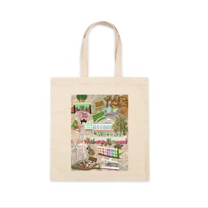May include: A white tote bag with a colorful illustration of Palm Springs landmarks. The illustration includes a pink building, a swimming pool, a windmill, and palm trees. The text "Palm Springs" is written in a retro font.