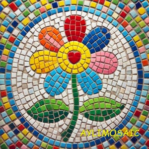 Op de afbeelding: Een kleurrijk mozaïek bloemontwerp met een rood hart in het midden, omringd door bloemblaadjes in rood, oranje, geel, roze en blauw. De bloem heeft een groene stengel en bladeren. Het mozaïek is gemaakt van kleine, vierkante tegels in verschillende kleuren. De tekst "AYLIMOSAIC" staat onderaan.