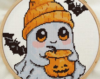May include: A white ghost wearing an orange knit hat holds a jack-o'-lantern. The ghost has large, black eyes and a small smile. A black bat is flying in the background.