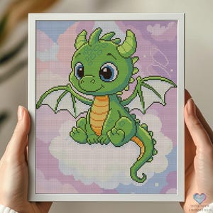 Può includere: Un piccolo drago verde con occhi grandi e ali seduto su una nuvola bianca su uno sfondo viola e rosa.