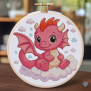 Peut inclure: Broderie au point de croix dans un cercle en bois. Elle représente un adorable dragon rose assis sur un nuage. Le dragon a des épines oranges et des ailes roses. Le fond est orné de petits nuages aux couleurs pastel. Un travail artisanal.
