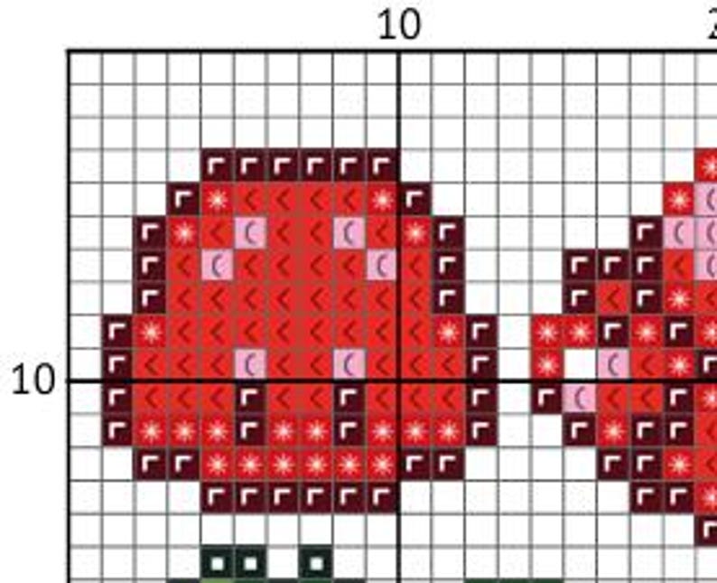 May include: A cross-stitch pattern featuring two red mushrooms with white and pink accents. The mushrooms are set against a grid background, with a green stem visible below the left mushroom. The pattern is designed for needlecraft.