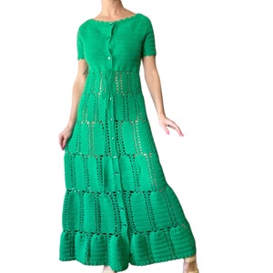 May include: A bright green crochet dress with short sleeves and a button-down front. The dress features a scalloped neckline and a tiered skirt with openwork detailing. A drawstring cinches the waist. The dress is a vibrant, eye-catching piece.